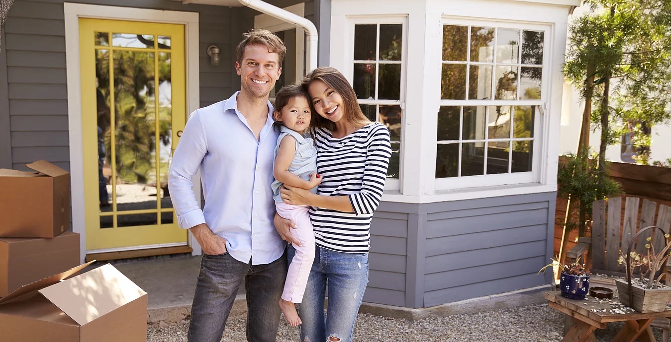 A family in front of their new home on moving day